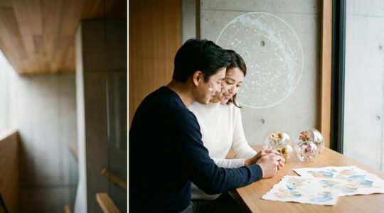 Elegant couple examining constellation map in minimalist wedding venue with soft ambient lighting