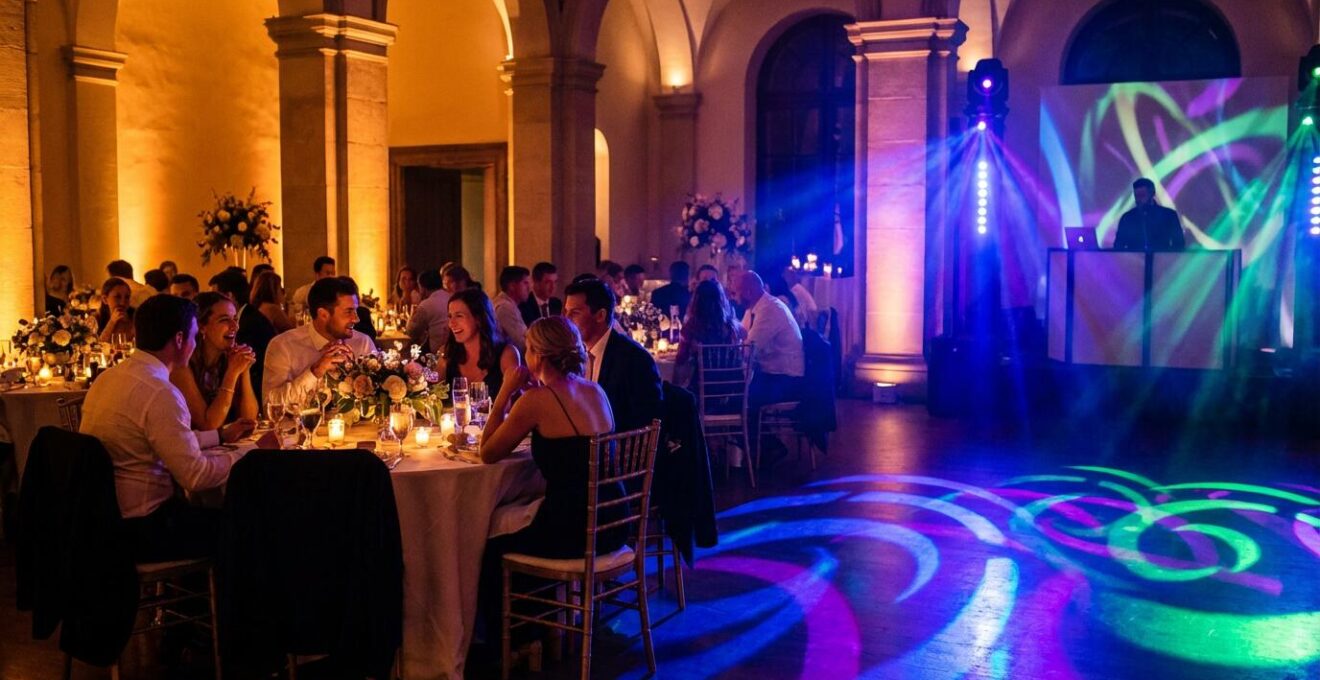Wide view of wedding reception showing gradual lighting transition from dinner to dancing